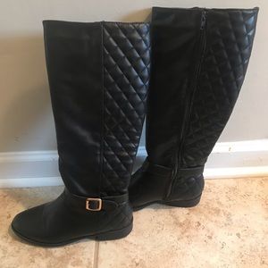 Black boots with gold buckle. Zips up on side